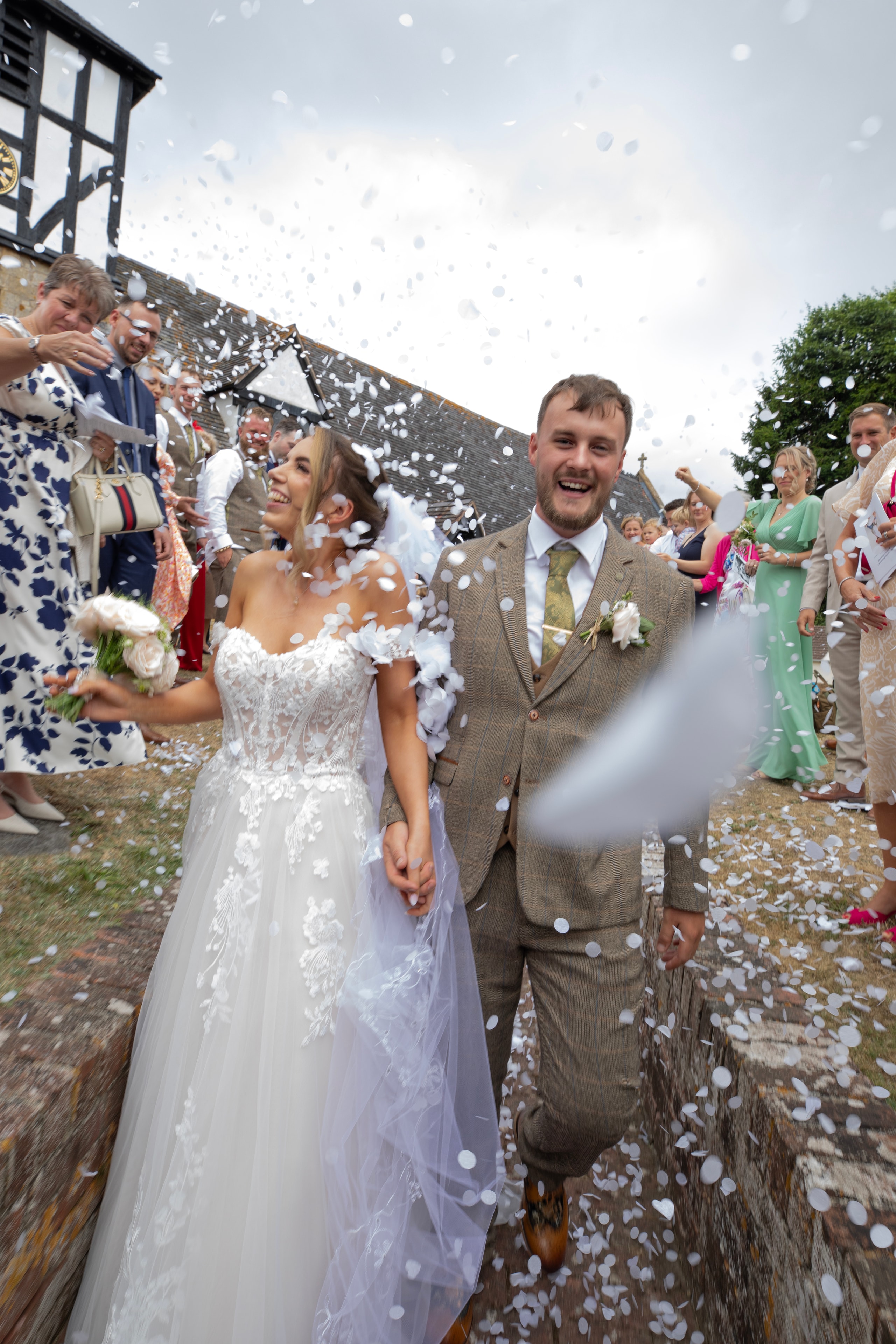 Bride and groom walking through confetti